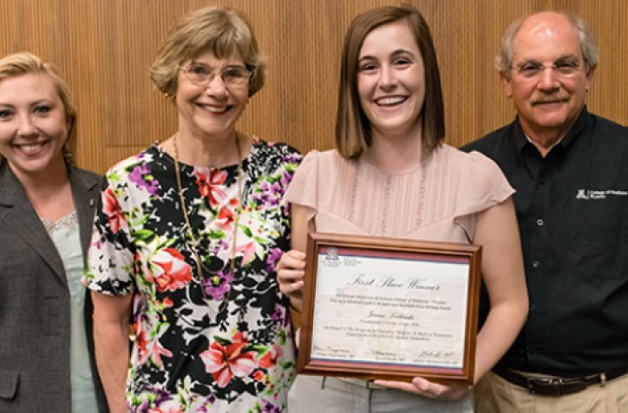 Jenna Koblinski poses in a group photo with award