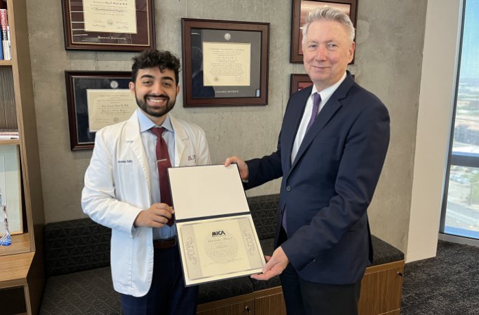 Armin Talle poses with Dean Guy Reed, MD, MS, after learning he received the award