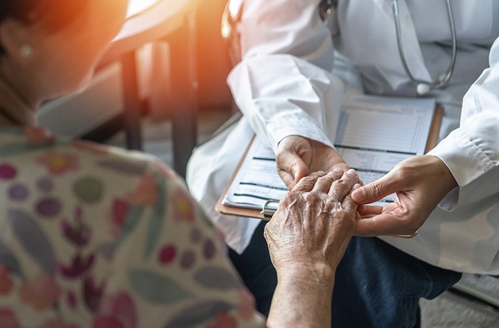 A doctor examines a patient's hand