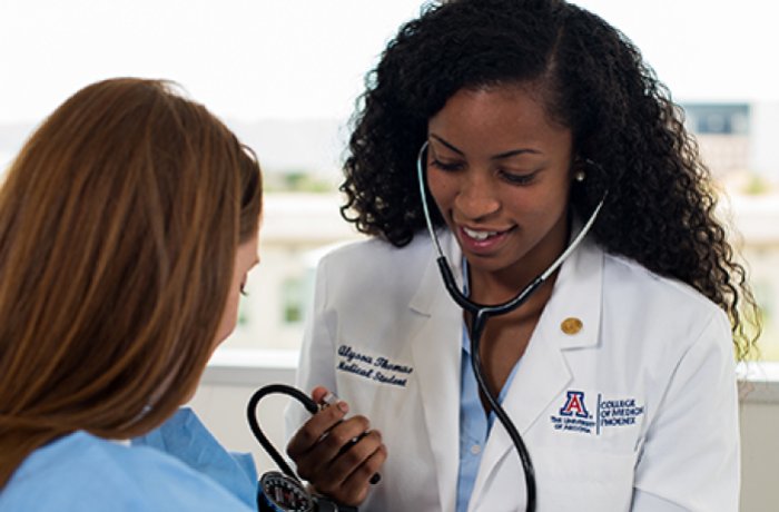 woman using blood pressure cuff and stethoscope 