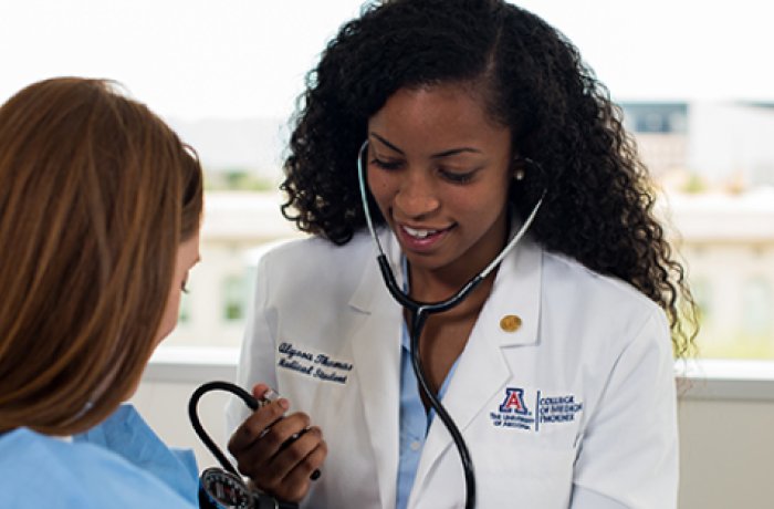 woman using blood pressure cuff and stethoscope 