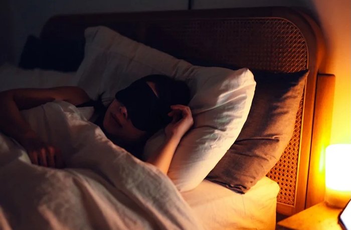 A woman sleeping in her bed (Credit: Oscar Wong/Getty Images)