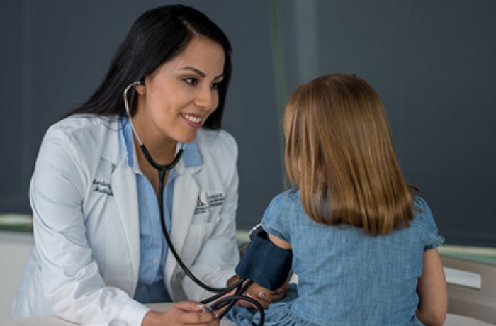 a doctor conducting a blood pressure exam on a child