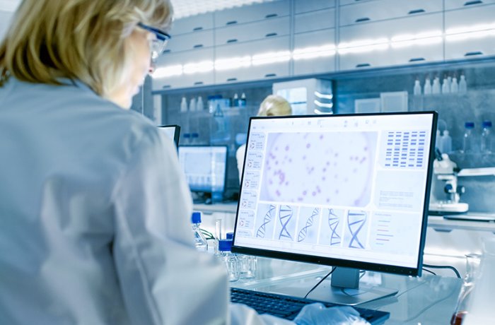 A Woman Examines DNA on Her Computer in a Laboratory 