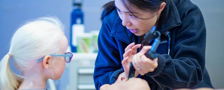 A Medical Student Demonstrates a Medical Procedure to an Attendee