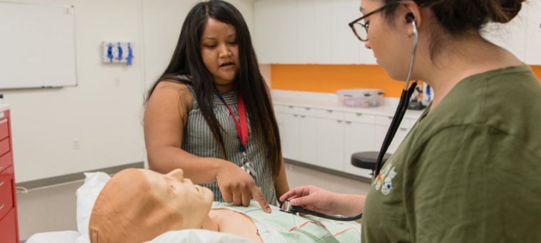 Students Examining a Simulation Mannequin in the Sim Center