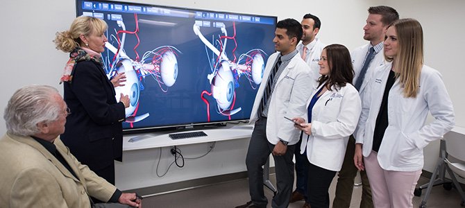ophthalmology professors speaking to medical students in front of big monitor