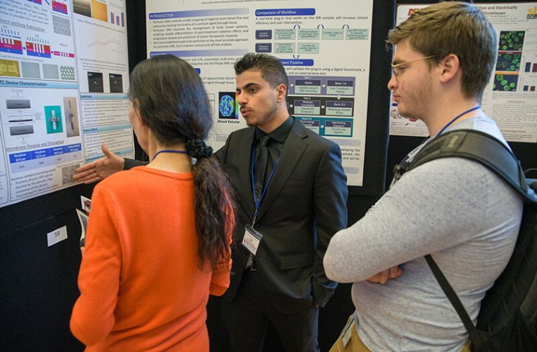 A Researcher Discusses His Findings with Attendees of the Conference A Researcher Discusses His Findings with Attendees of the Conference