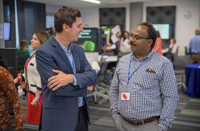 Tim Marlowe, PhD, Talks with an Attendee at the Research Office Open House