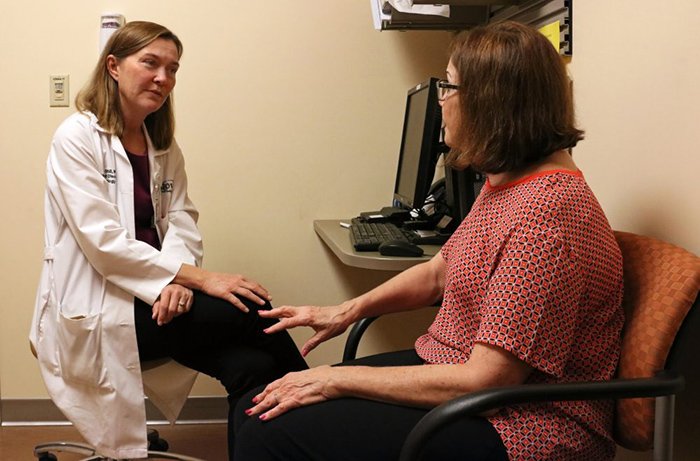 Holly Shill, MD, Talks with a Patient in Her Office