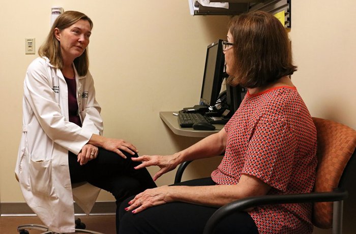 Holly Shill, MD, Talks with a Patient in Her Office Holly Shill, MD, Talks with a Patient in Her Office