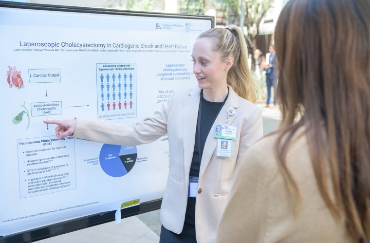 Fourth-year medical student Laurel Gieseke discusses her Scholar Project, Laparoscopic Cholecystectomy in Cardiogenic Shock or Heart Failure, with an attendee Fourth-year medical student Laurel Gieseke discusses her Scholar Project, Laparoscopic Cholecystectomy in Cardiogenic Shock or Heart Failure, with an attendee