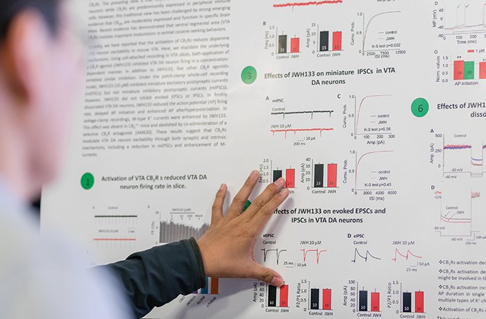 Researcher Presents Her Poster to an Attendee Researcher Presents Her Poster to an Attendee