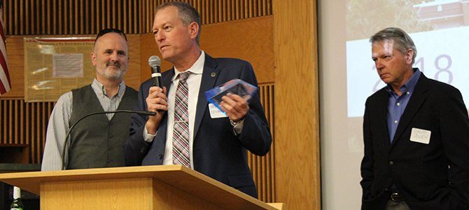 Frederic Zenhausern, PhD, MBA standing at a lectern holding a microphone