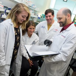 PhD Laboratory Team Looks Over Research Notes