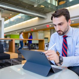 A Medical Student Works on His iPad in the Library